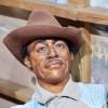 A wax statue of a black man with a thin mustache wearing a cowboy hat and western shirt. 